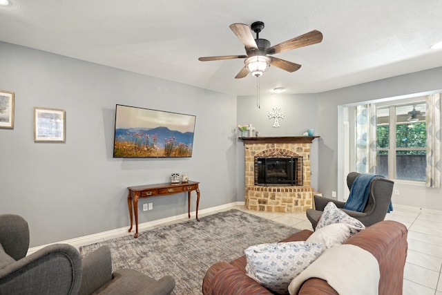 living room featuring ceiling fan, a fireplace, and light tile patterned floors