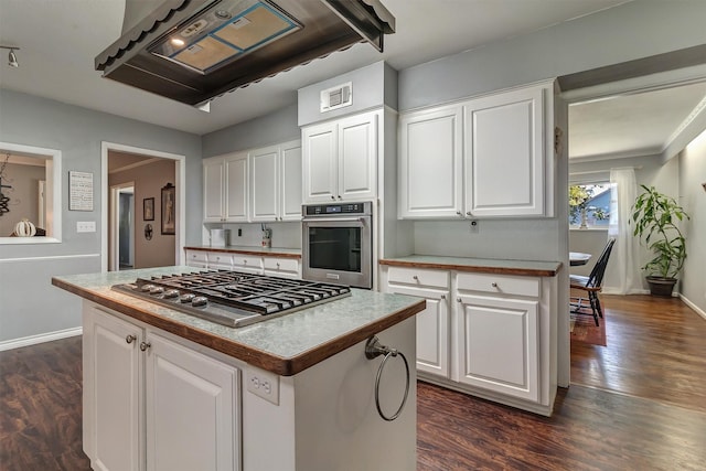 kitchen with white cabinets, appliances with stainless steel finishes, and a center island