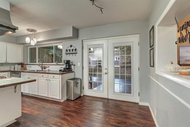 kitchen with dark wood-type flooring, french doors, sink, hanging light fixtures, and white cabinetry