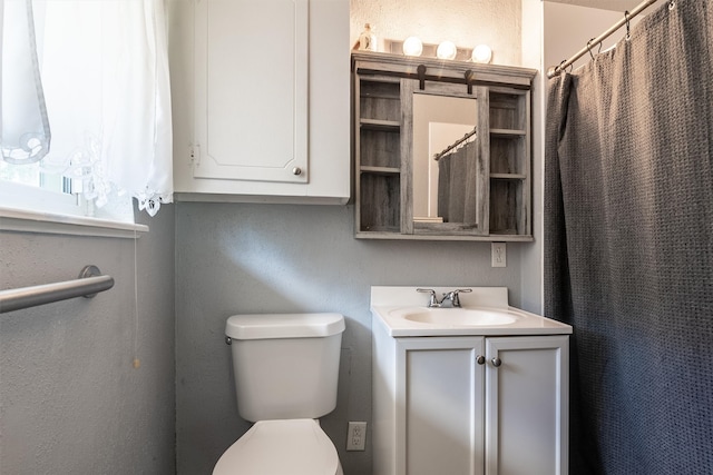 bathroom featuring vanity, toilet, and curtained shower