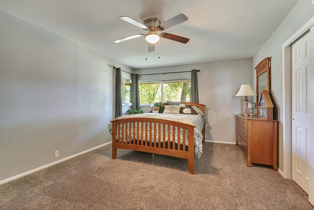 carpeted bedroom with ceiling fan and a closet