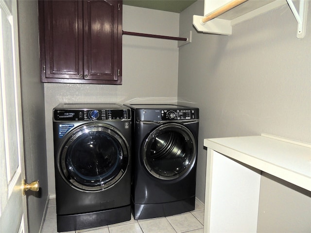 laundry area featuring cabinets, light tile patterned floors, and separate washer and dryer