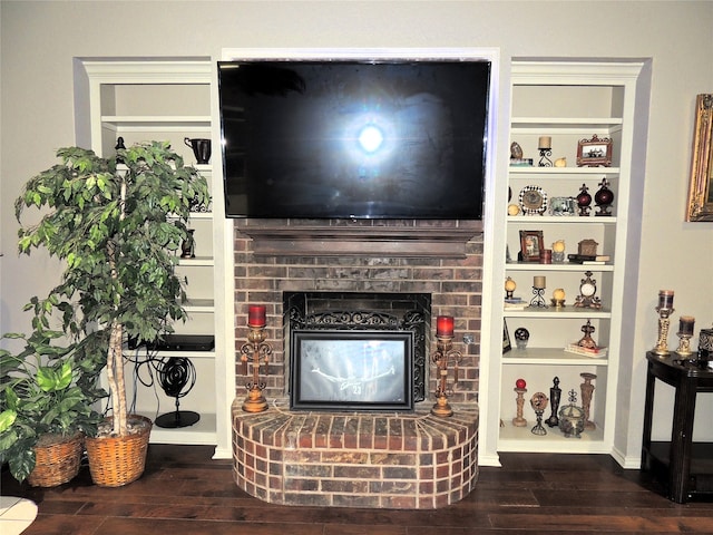 living room featuring dark wood-type flooring and a brick fireplace