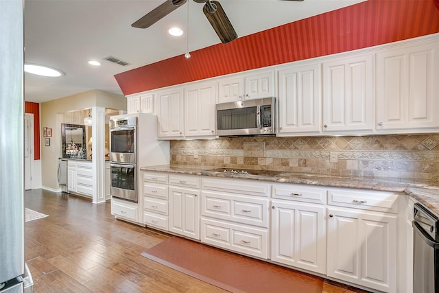 kitchen with ceiling fan, backsplash, white cabinetry, stainless steel appliances, and light hardwood / wood-style floors