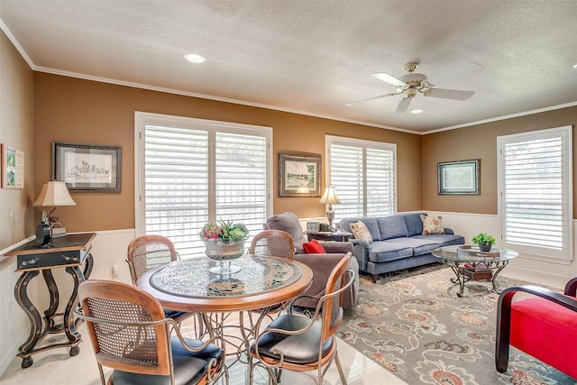 dining area with ceiling fan, a healthy amount of sunlight, and a textured ceiling