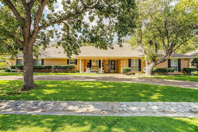 ranch-style house featuring a front lawn and a porch