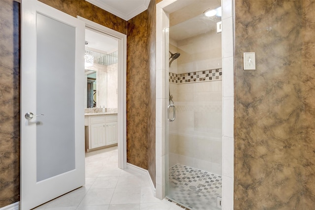 bathroom with vanity, a shower with shower door, and ornamental molding