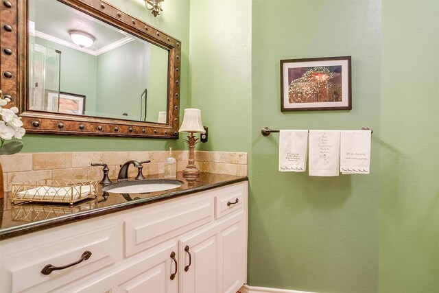 bathroom featuring ornamental molding, backsplash, and vanity