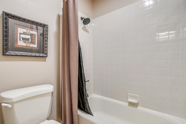 bathroom featuring shower / tub combo and toilet