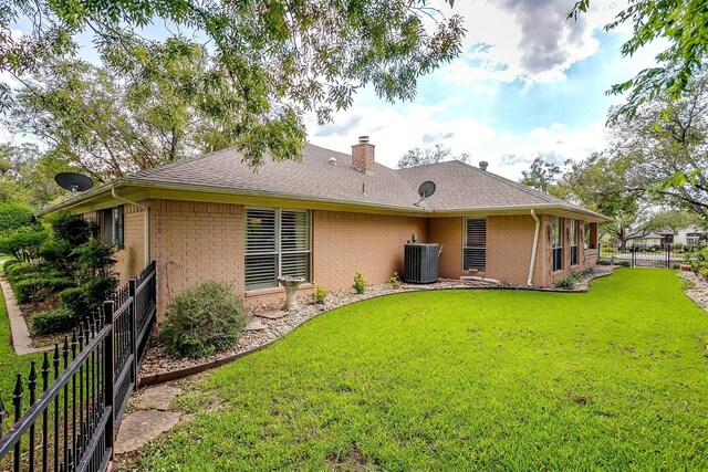 back of property with a yard and central air condition unit