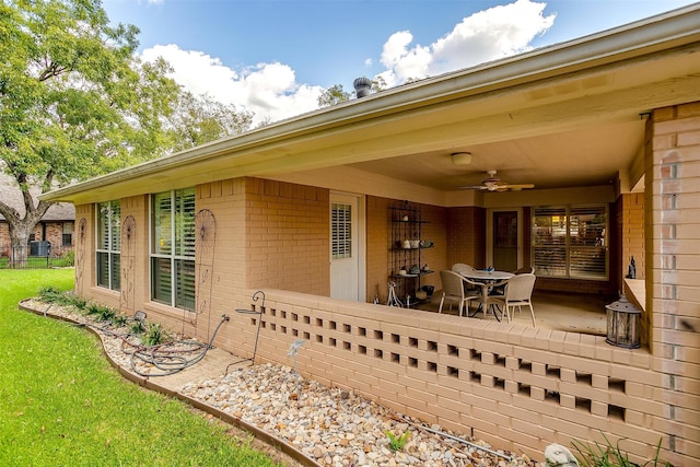 exterior space featuring ceiling fan and a lawn