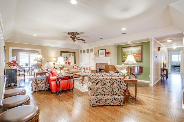 living room featuring ornamental molding, light hardwood / wood-style floors, ceiling fan, and plenty of natural light