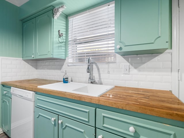 kitchen featuring green cabinetry, white dishwasher, tasteful backsplash, and sink