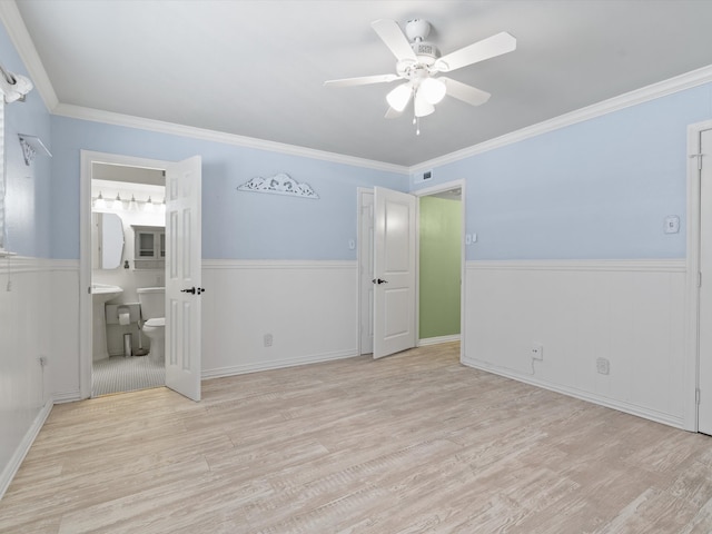 unfurnished bedroom with ornamental molding, light wood-type flooring, ensuite bath, and ceiling fan