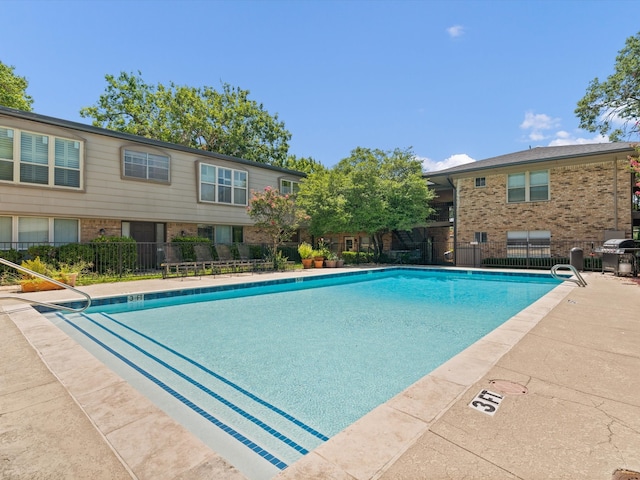 view of swimming pool featuring grilling area