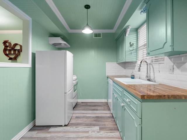 kitchen featuring light hardwood / wood-style floors, white appliances, pendant lighting, sink, and wood counters