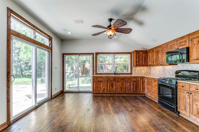 kitchen with light stone counters, backsplash, dark hardwood / wood-style flooring, black appliances, and ceiling fan