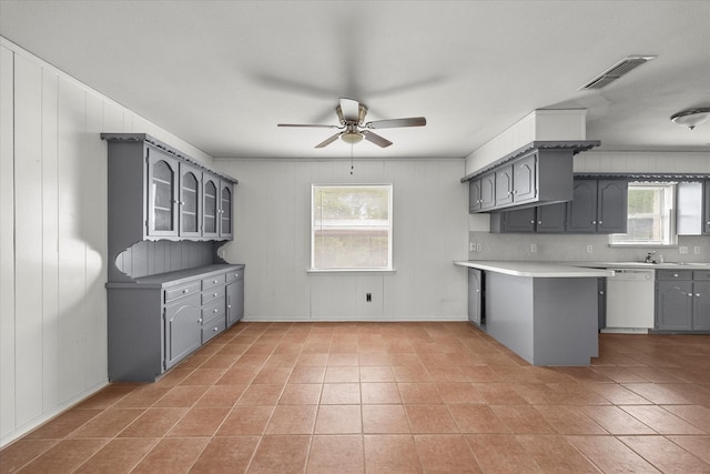 kitchen with gray cabinetry, kitchen peninsula, white dishwasher, tile patterned flooring, and ceiling fan