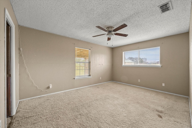 spare room with ceiling fan, a textured ceiling, plenty of natural light, and carpet flooring