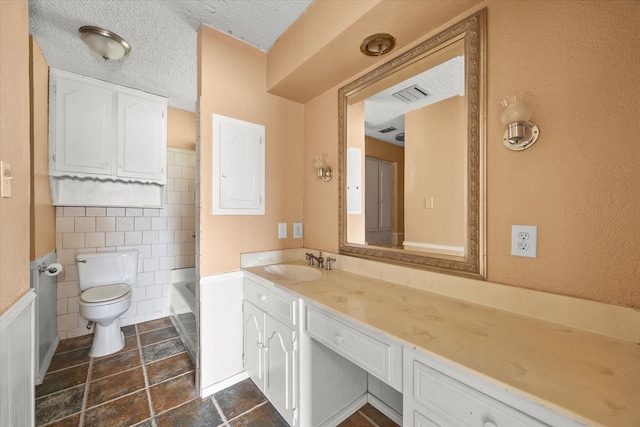 full bathroom featuring vanity, a textured ceiling, shower / tub combination, tile walls, and toilet