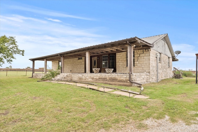 back of house featuring a yard and a rural view