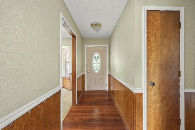 doorway to outside featuring a textured ceiling and dark hardwood / wood-style floors