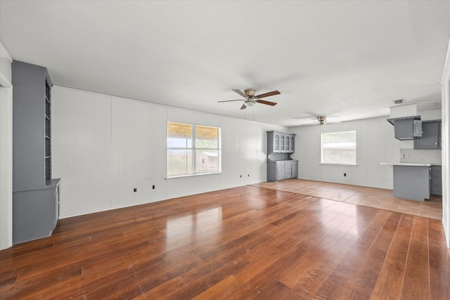 unfurnished living room with ceiling fan and hardwood / wood-style flooring