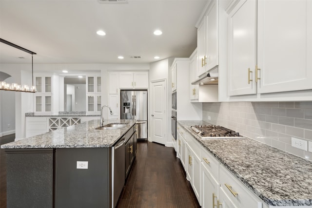 kitchen with dark wood-type flooring, sink, an island with sink, white cabinets, and appliances with stainless steel finishes