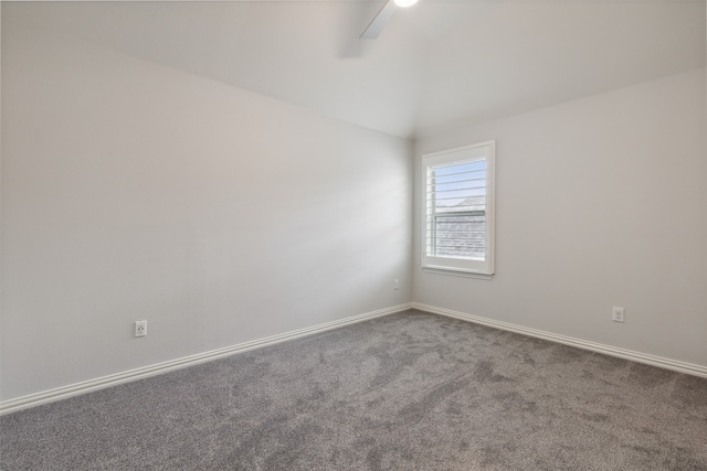 empty room with carpet flooring and vaulted ceiling