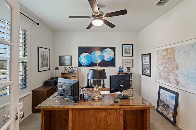 carpeted home office featuring ceiling fan