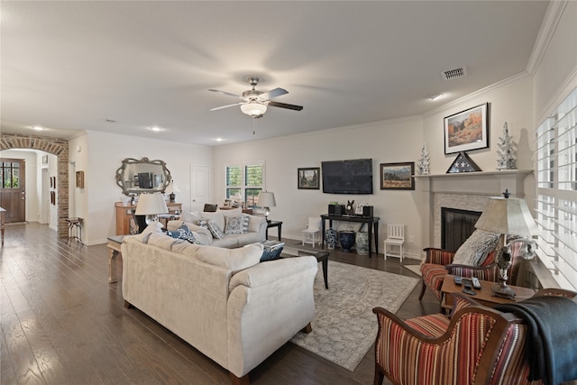 living room featuring ceiling fan, plenty of natural light, dark wood-type flooring, and ornamental molding