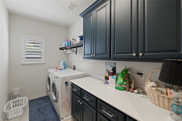 laundry room with cabinets, light tile patterned floors, and washing machine and dryer