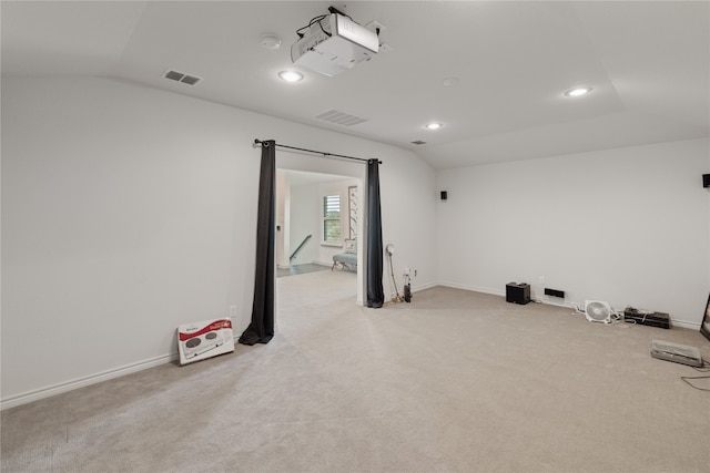 workout room with light colored carpet and vaulted ceiling