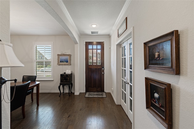 foyer with french doors, dark wood-type flooring, a textured ceiling, and ornamental molding