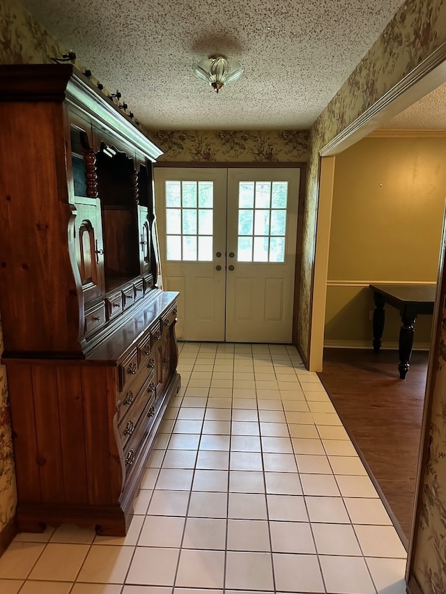 doorway featuring light hardwood / wood-style flooring, a textured ceiling, and french doors