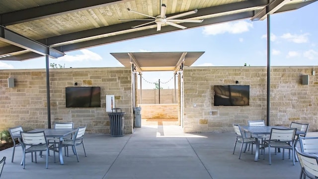 view of patio featuring ceiling fan, outdoor dining space, and a fireplace