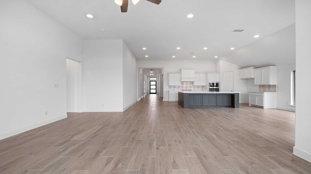 unfurnished living room featuring lofted ceiling, recessed lighting, visible vents, light wood-style flooring, and ceiling fan