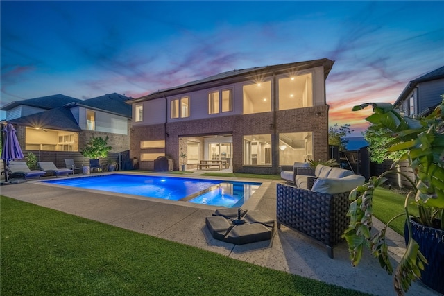 back house at dusk featuring a fenced in pool, a patio, an outdoor living space, and a lawn