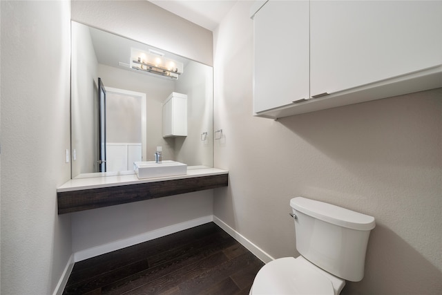 bathroom with hardwood / wood-style flooring, toilet, and sink