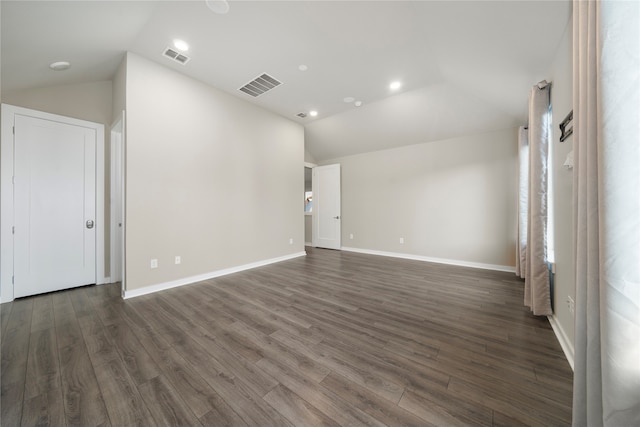 spare room with lofted ceiling and dark wood-type flooring