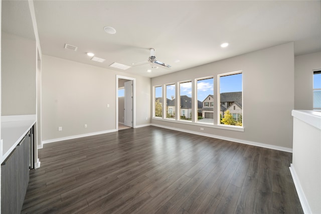 unfurnished living room with ceiling fan and dark wood-type flooring