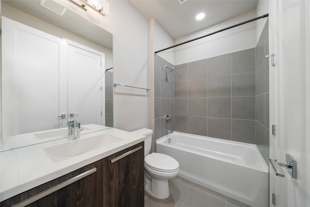 full bathroom with tile patterned flooring, vanity, tiled shower / bath combo, and toilet