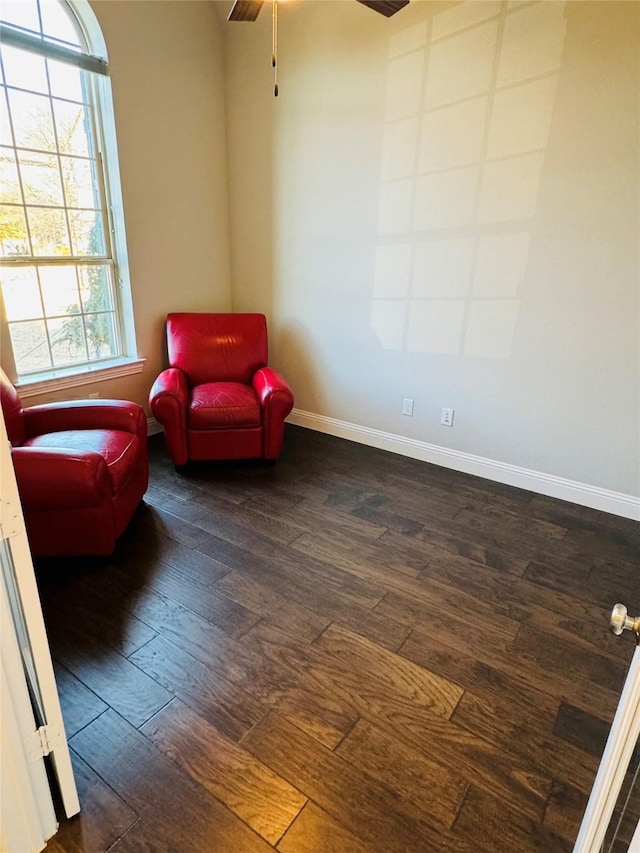 sitting room featuring ceiling fan, baseboards, and dark wood-type flooring