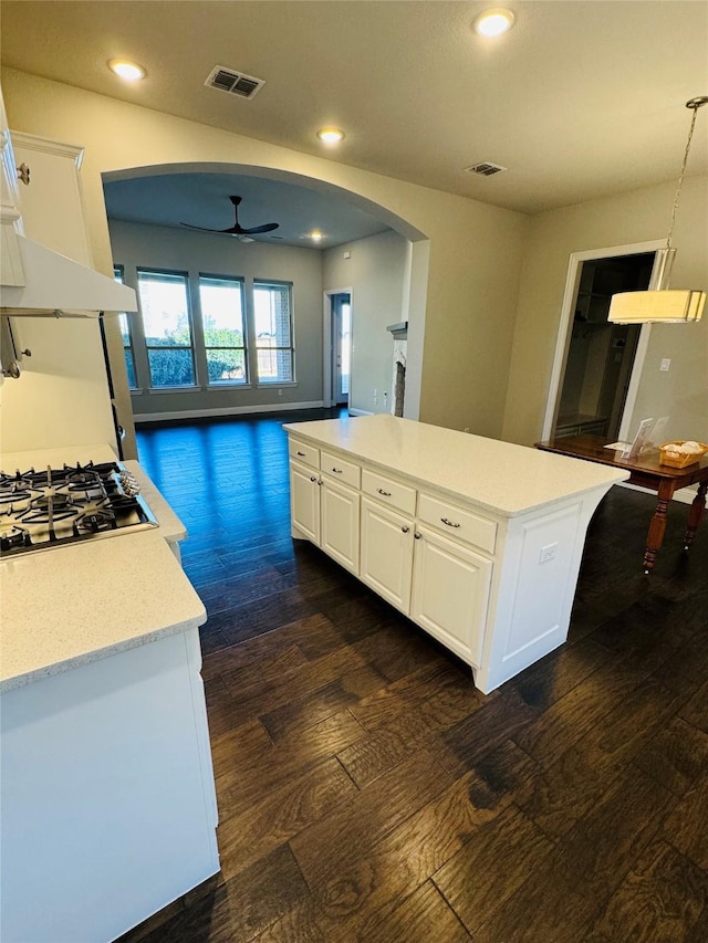 kitchen with a center island, white cabinets, light countertops, and visible vents