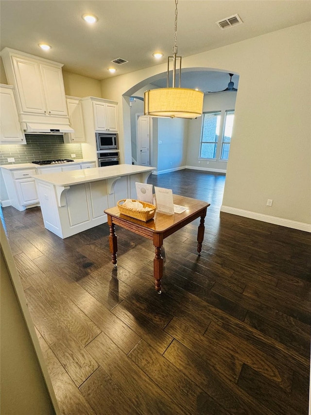 kitchen with appliances with stainless steel finishes, white cabinets, light countertops, and a kitchen island