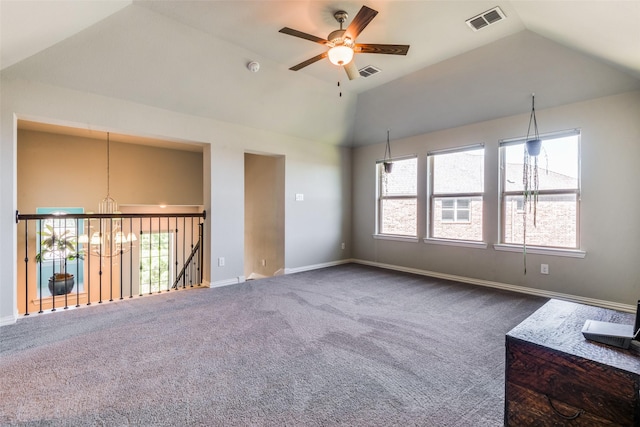 unfurnished room featuring lofted ceiling, a healthy amount of sunlight, visible vents, and dark colored carpet