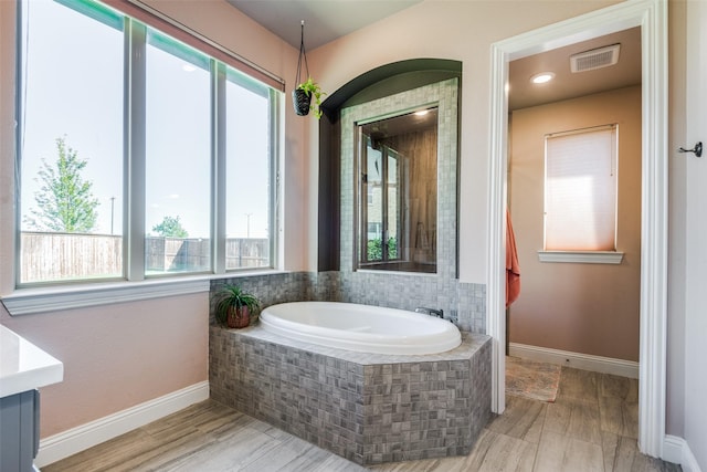 bathroom featuring a garden tub, visible vents, and baseboards