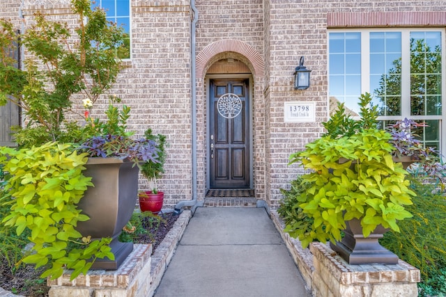 entrance to property featuring brick siding