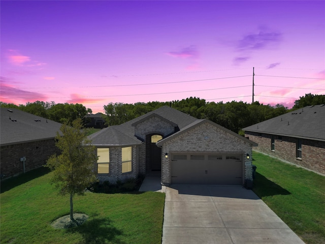 view of front of home featuring a garage and a yard