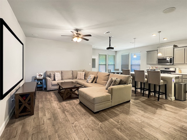 living room featuring wood-type flooring and ceiling fan